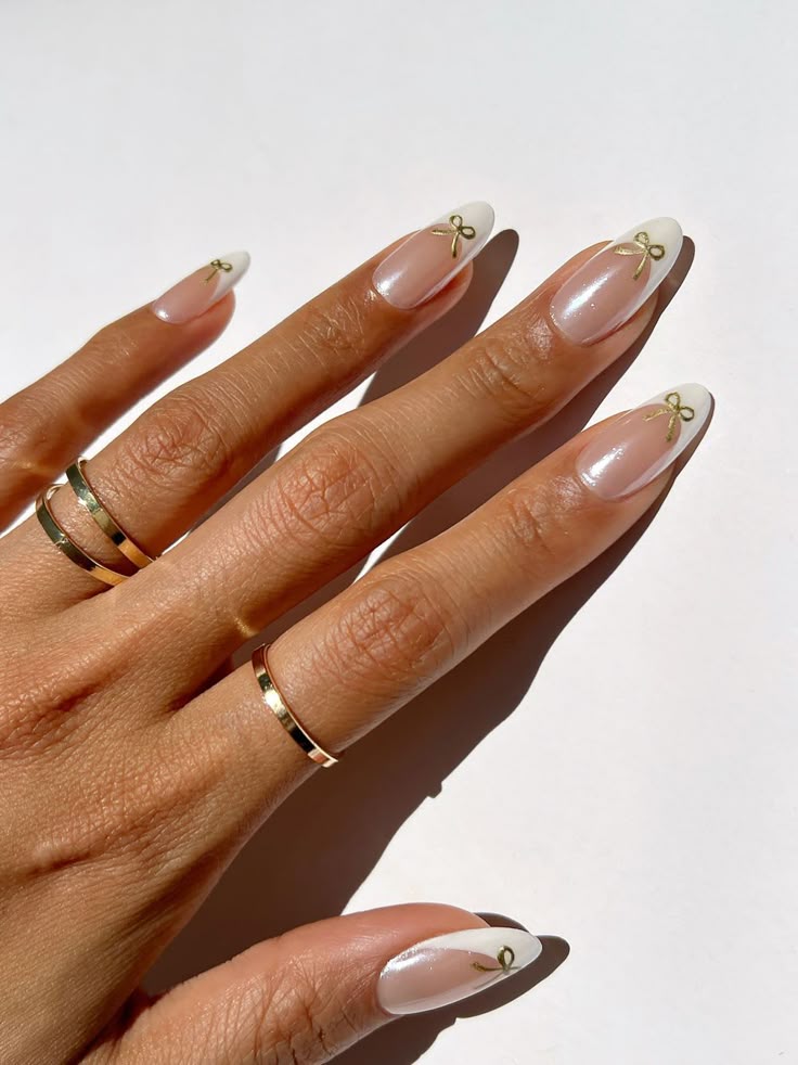 Weiß und goldene Coquette -Nägel mit Bogendetails