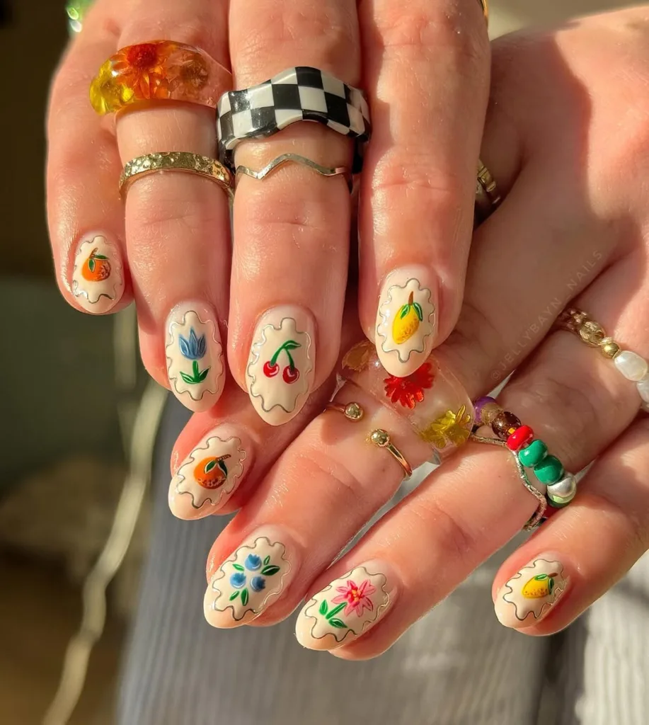 Mandelgelee weiße Nägel mit farbenfrohen Y2K -Blumen- und Obst -Designs, perfekt für den Frühling 2025.