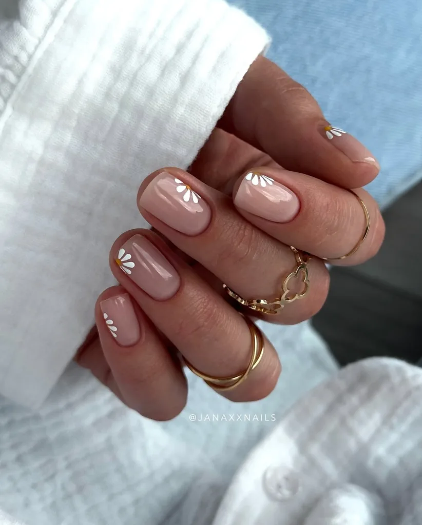 Transparente Nägel mit minimalen weißen Gänseblümchenblumen, ideal für einen weichen Feder -Look.