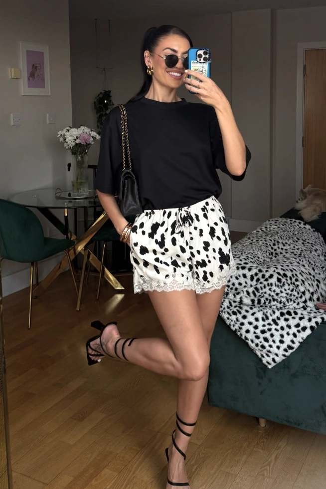 Casual Spitzenshorts in Weiß mit schwarzen Tupfen mit einer zarten Spitzenverkleidung, perfekt für Sommerausflüge oder Brunch.