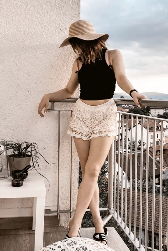 Sahne Spitzenshorts gepaart mit einem montierten schwarzen Tanktop, perfekt für ungezwungene Sommerausflüge oder Strandtage.