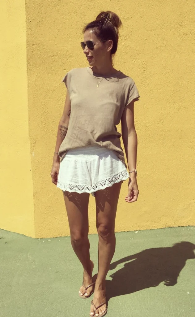 Ein lässiges Outfit mit einem beige T-Shirt und einem weißen Spitzenverkleidungsshorts, perfekt für Sommerausflüge oder Strandtage.