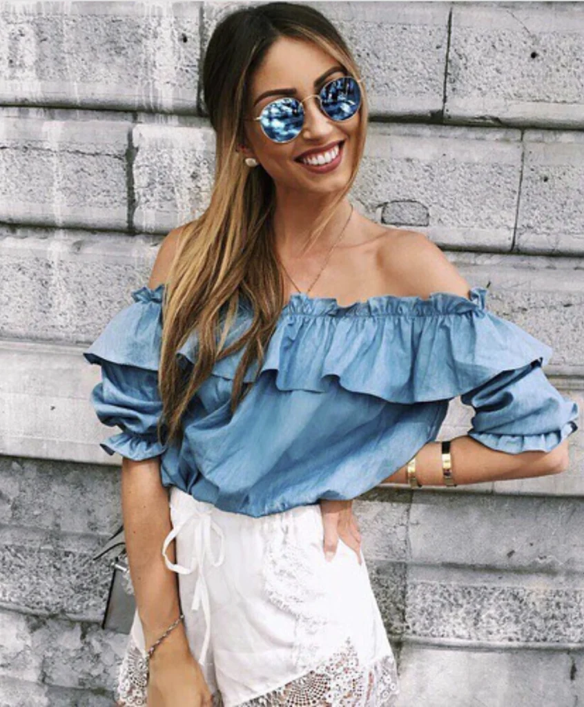 Casual Off-Shoulder Denim Top mit gekräuselten Ärmeln, gepaart mit weißen Spitzenshorts, ideal für Sommerausflüge oder Brunch.