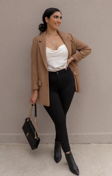 Elegantes Satin-Cami-Top in Weiß, gepaart mit einer beige Blazer und schwarzen Jeans mit hoher Tapfle; Perfekt für lässige oder semi-formale Anlässe.