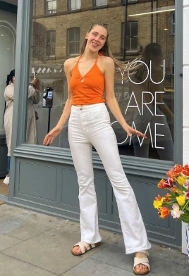 Orange Neckholder Cami Top gepaart mit weißen Flare -Jeans, perfekt für Freizeitausflüge oder Sommerveranstaltungen.