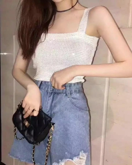 Weißes Strick -Cami -Top mit quadratischem Ausschnitt, gepaart mit einem verzweifelten Jeansrock; Perfekt für Gelegenheitsausflüge oder Sommerveranstaltungen.